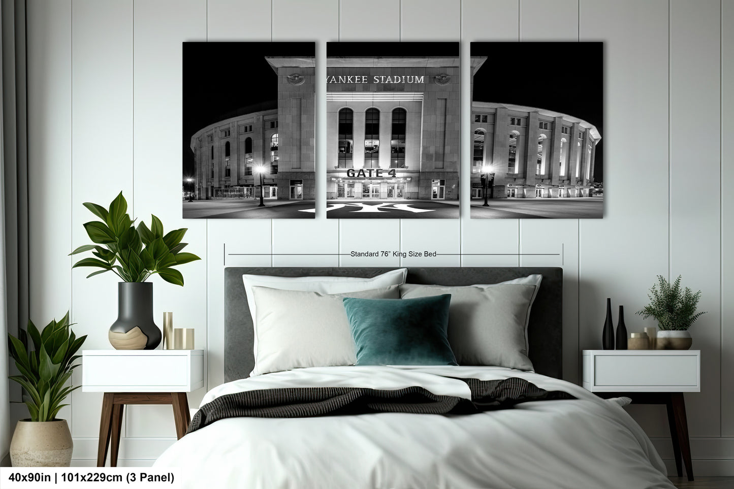 A bedroom with a large wall-mounted print of the Yankee Stadium in New York City at night. The print features the stadium's exterior and surrounding area, with the words "Yankee Stadium" prominently displayed. The print is framed by a black border, and the dimensions are provided as "40in (101.29cm) (3 panel)".