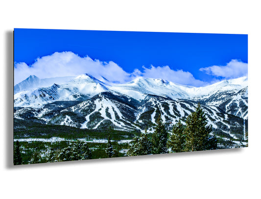 a snow covered mountain range under a blue sky