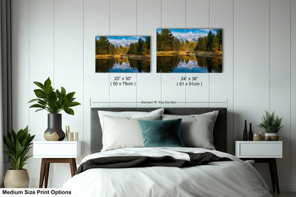 a bed room with a neatly made bed and two pictures on the wall