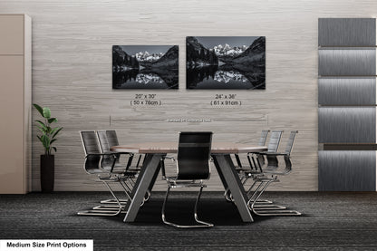 a dining room table with chairs next to a wall with pictures on it