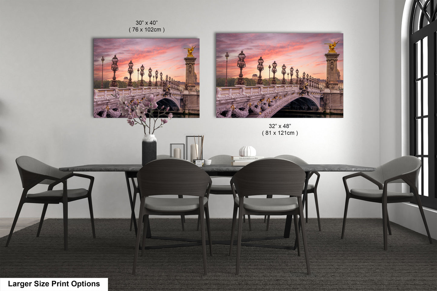 a dining room table with four chairs and two pictures on the wall