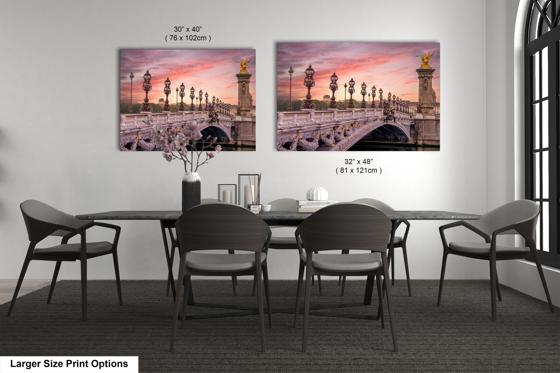 a dining room table with four chairs and two pictures on the wall