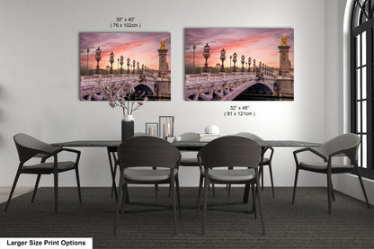 a dining room table with four chairs and two pictures on the wall