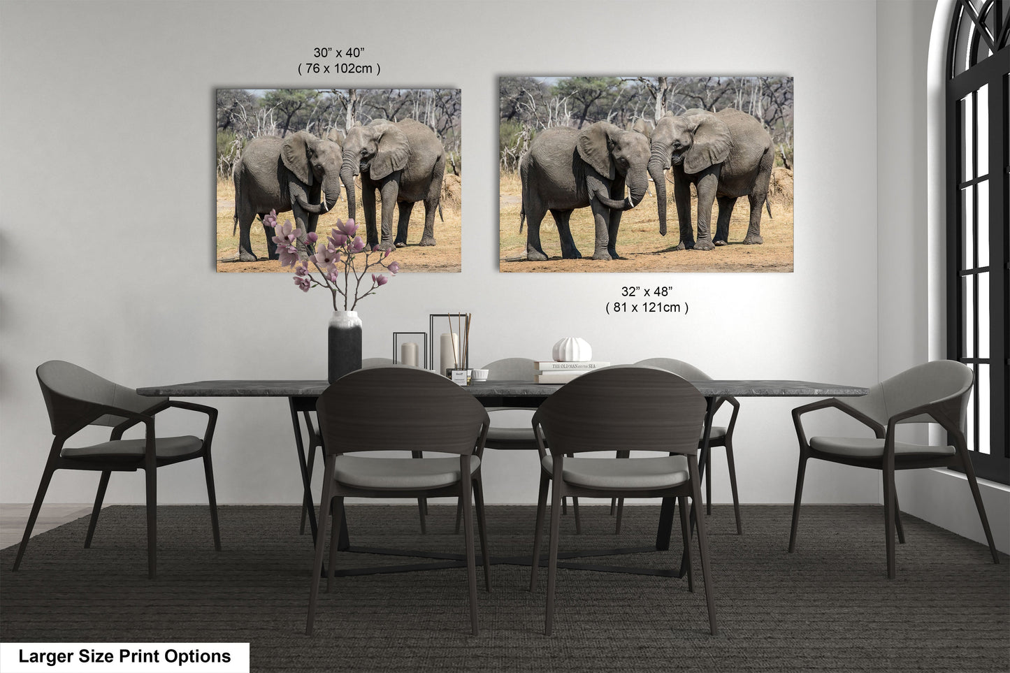 a dining room table with chairs and two pictures of elephants on the wall