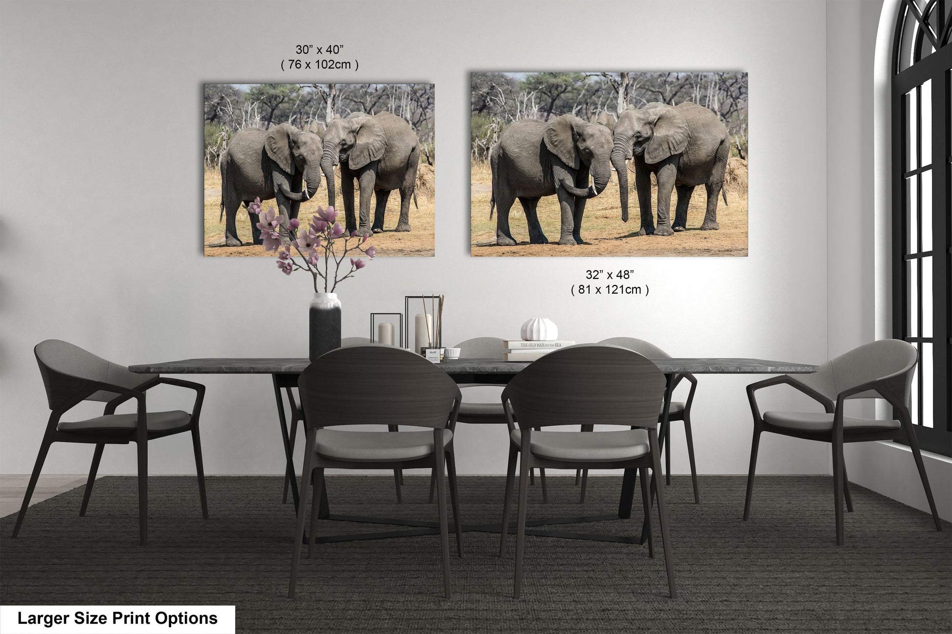 a dining room table with chairs and two pictures of elephants on the wall