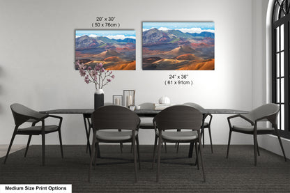 a modern dining room with a large black table surrounded by six chairs. Two large landscape paintings are displayed on the wall above the table, depicting a mountainous desert scene. The paintings are framed in a medium size, and the dimensions are provided in inches.