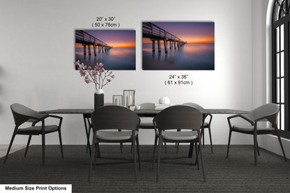 a dining room table with four chairs and a picture of a pier