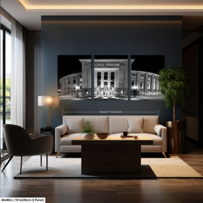 A modern living room with a large wall-mounted photograph of Yankee Stadium as the focal point. The photograph is a triptych, with the left and right panels showing the exterior of the stadium and the middle panel providing a detailed view of the stadium's interior. The room is furnished with a sofa, a coffee table, and a potted plant, creating a cozy and inviting atmosphere.
