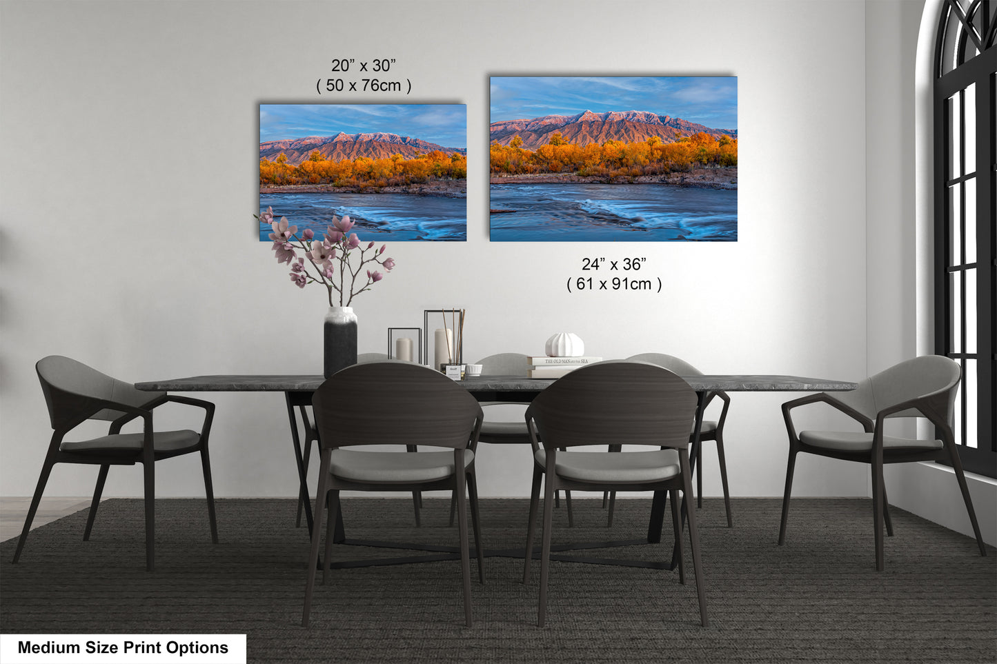 a dining table with four chairs and a vase with flowers