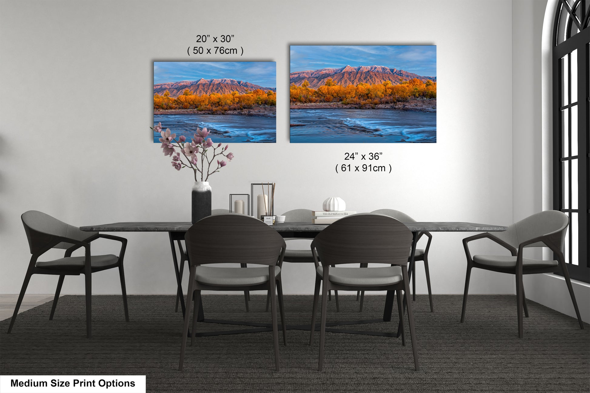 a dining table with four chairs and a vase with flowers