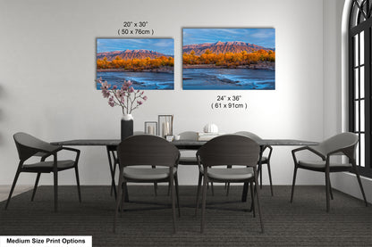a dining table with four chairs and a vase with flowers