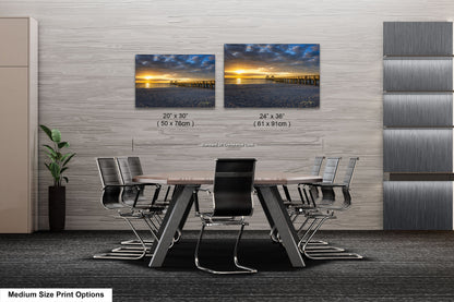 a dining room table with chairs and two pictures on the wall