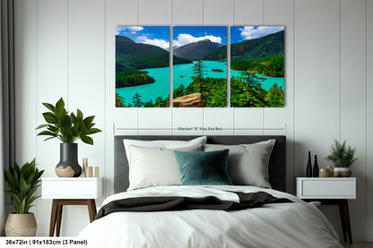 A bedroom with a large, three-panel landscape painting hanging on the wall above the bed. The painting depicts a scenic mountain lake surrounded by lush green forests.