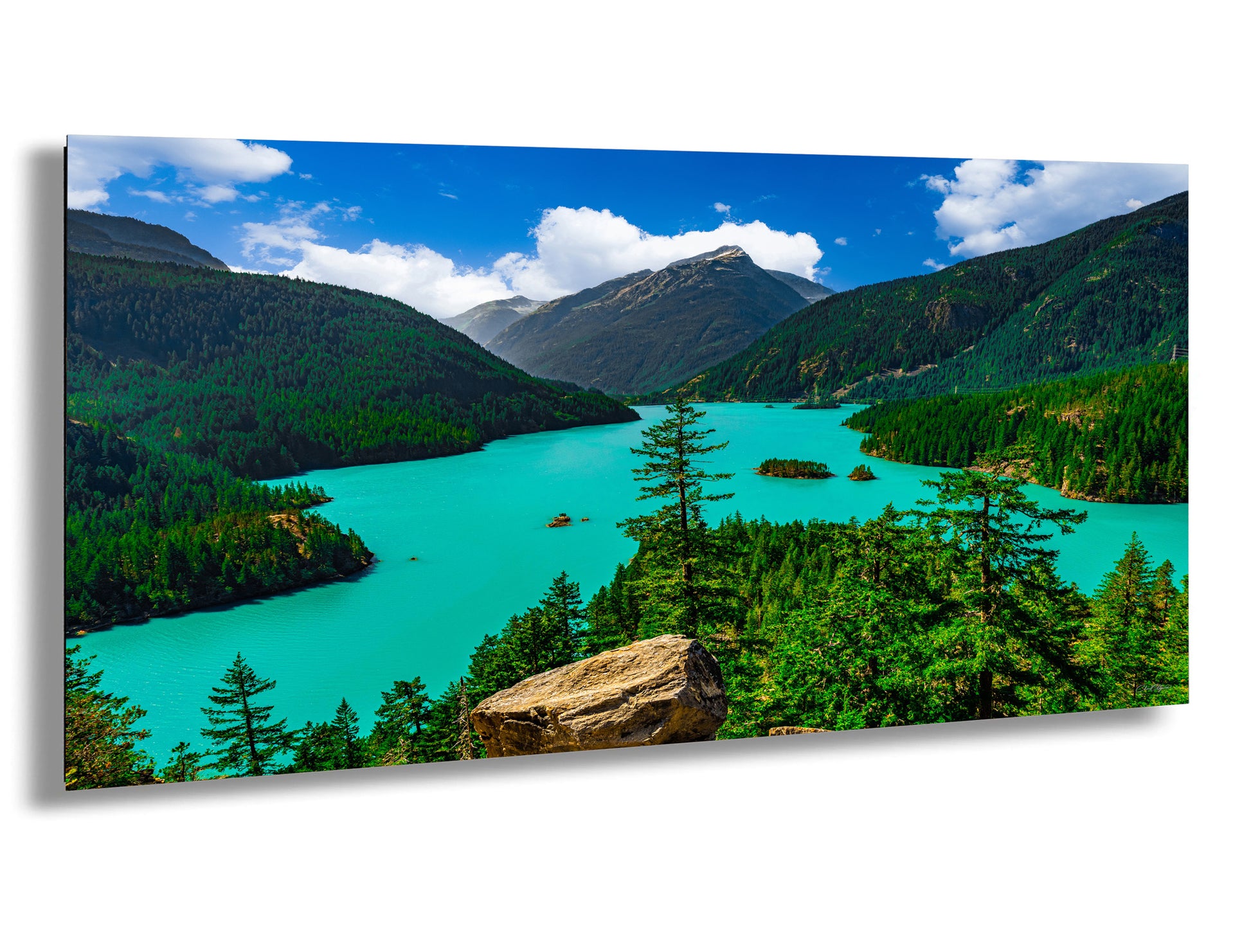 a stunning natural landscape with a turquoise lake surrounded by lush green forests and towering mountains.