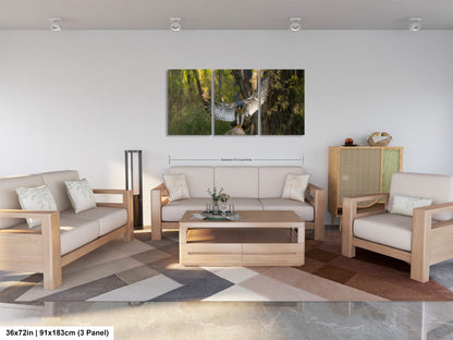 A modern living room with a large, three-panel landscape painting depicting a bird in flight over a forest. The room is furnished with a sofa, two armchairs, and a coffee table, creating a comfortable and inviting atmosphere.
