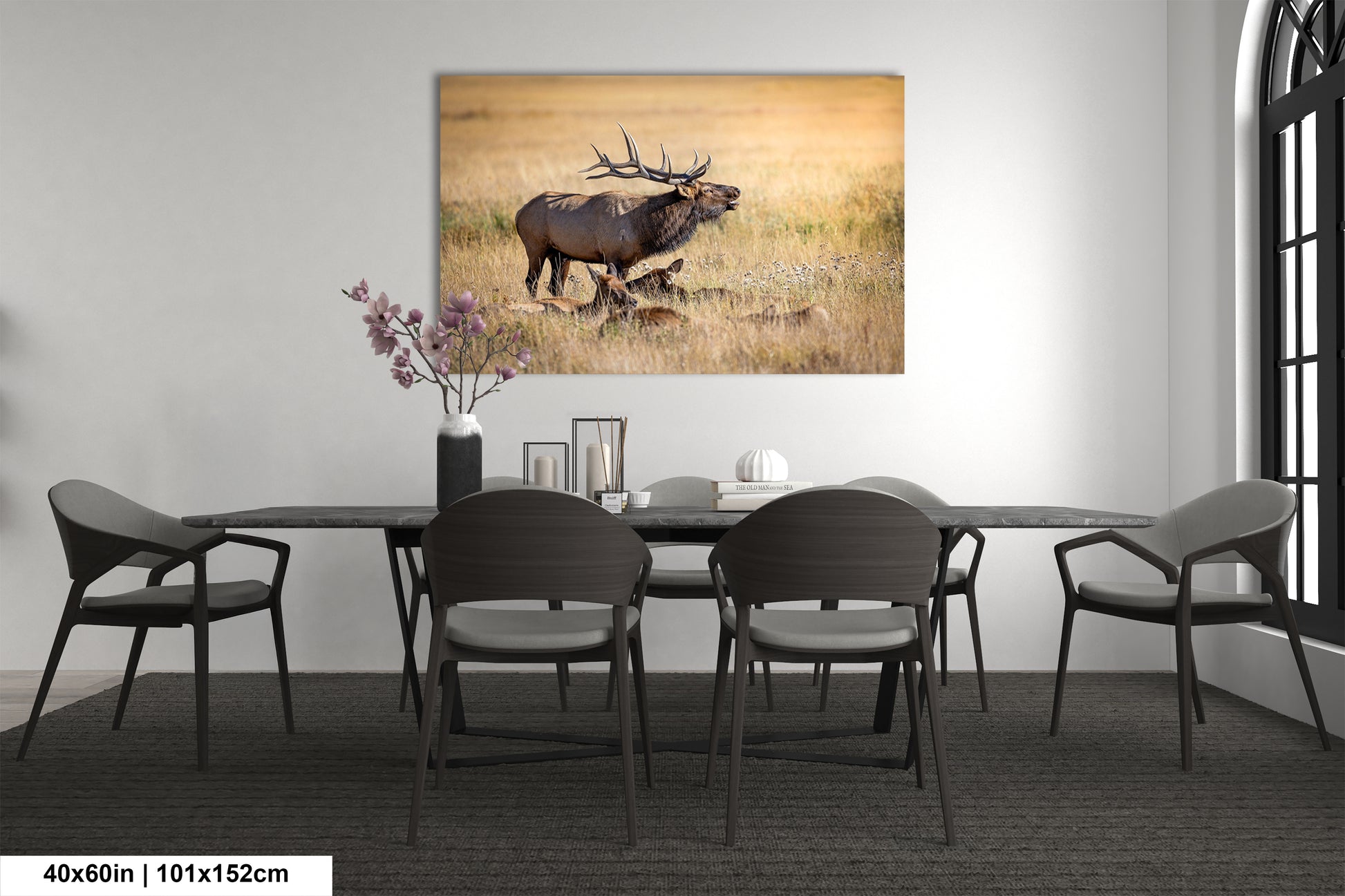 a dining room table with chairs and a painting of an elk