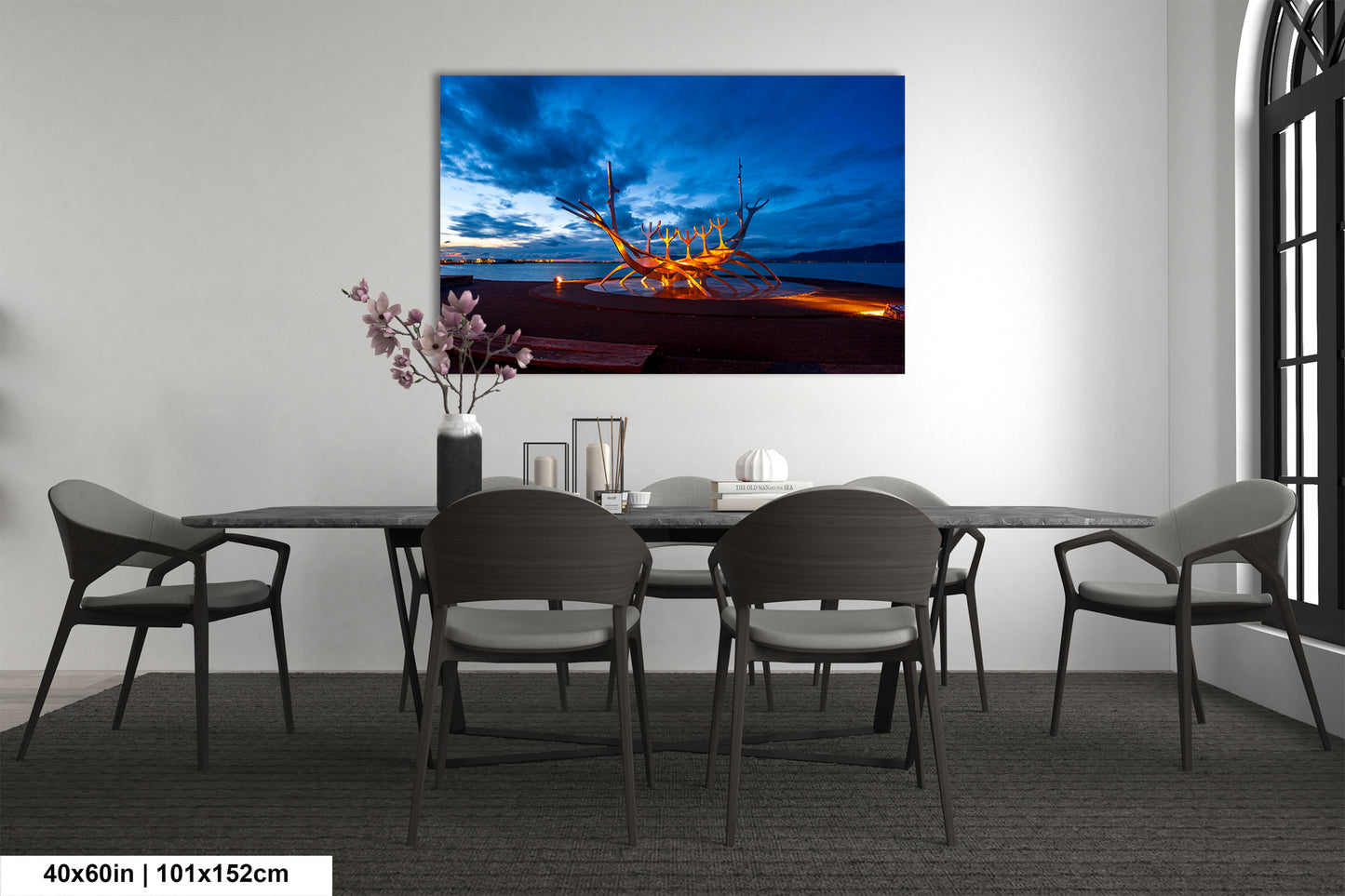 a dining room table with chairs and a painting on the wall