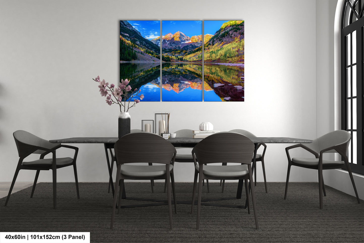 a dining room table with chairs and a painting on the wall