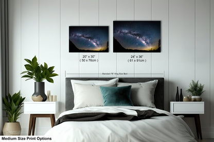 a bed with two pictures of the night sky above it