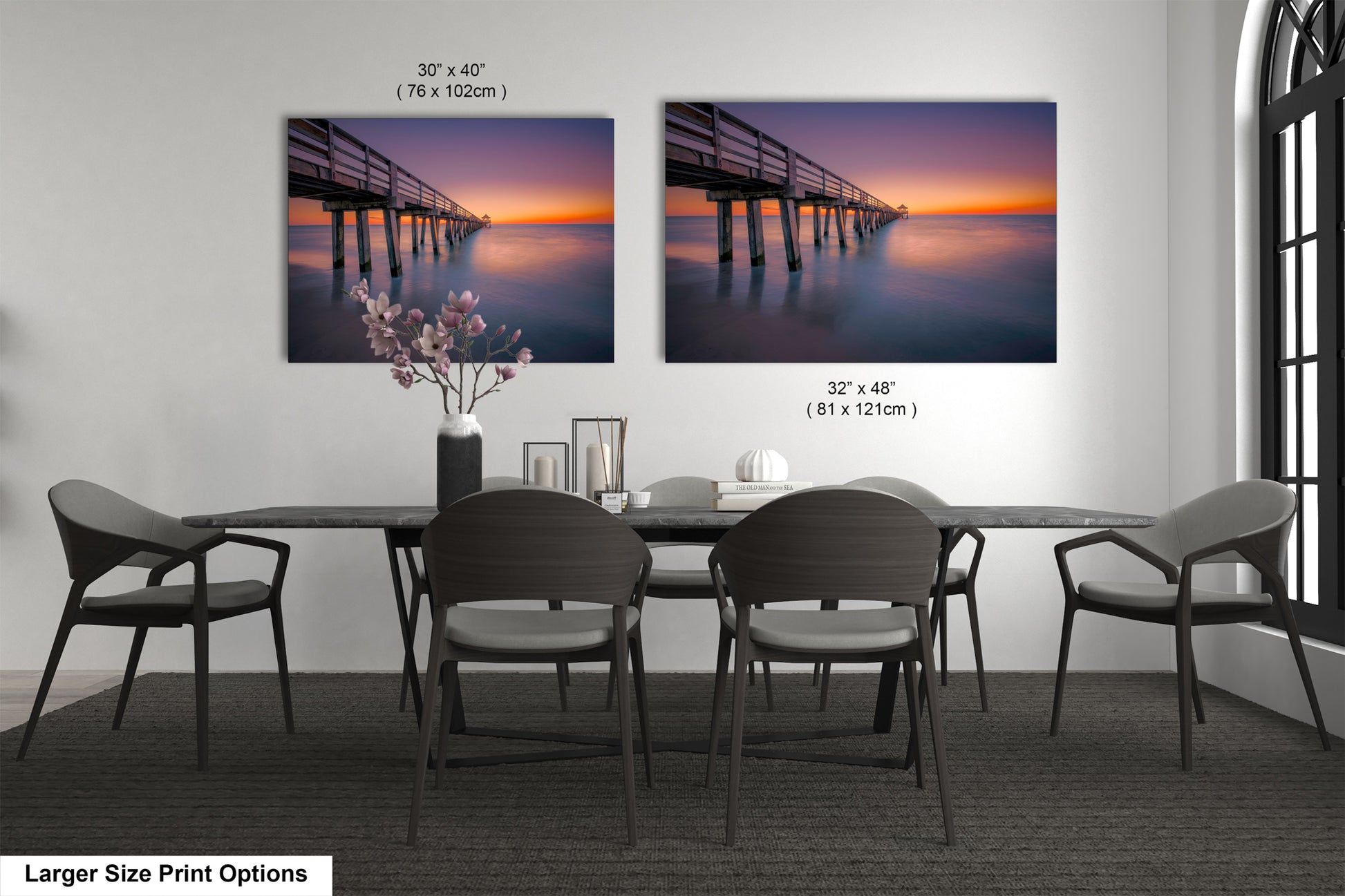 a dining room table with four chairs and two pictures on the wall