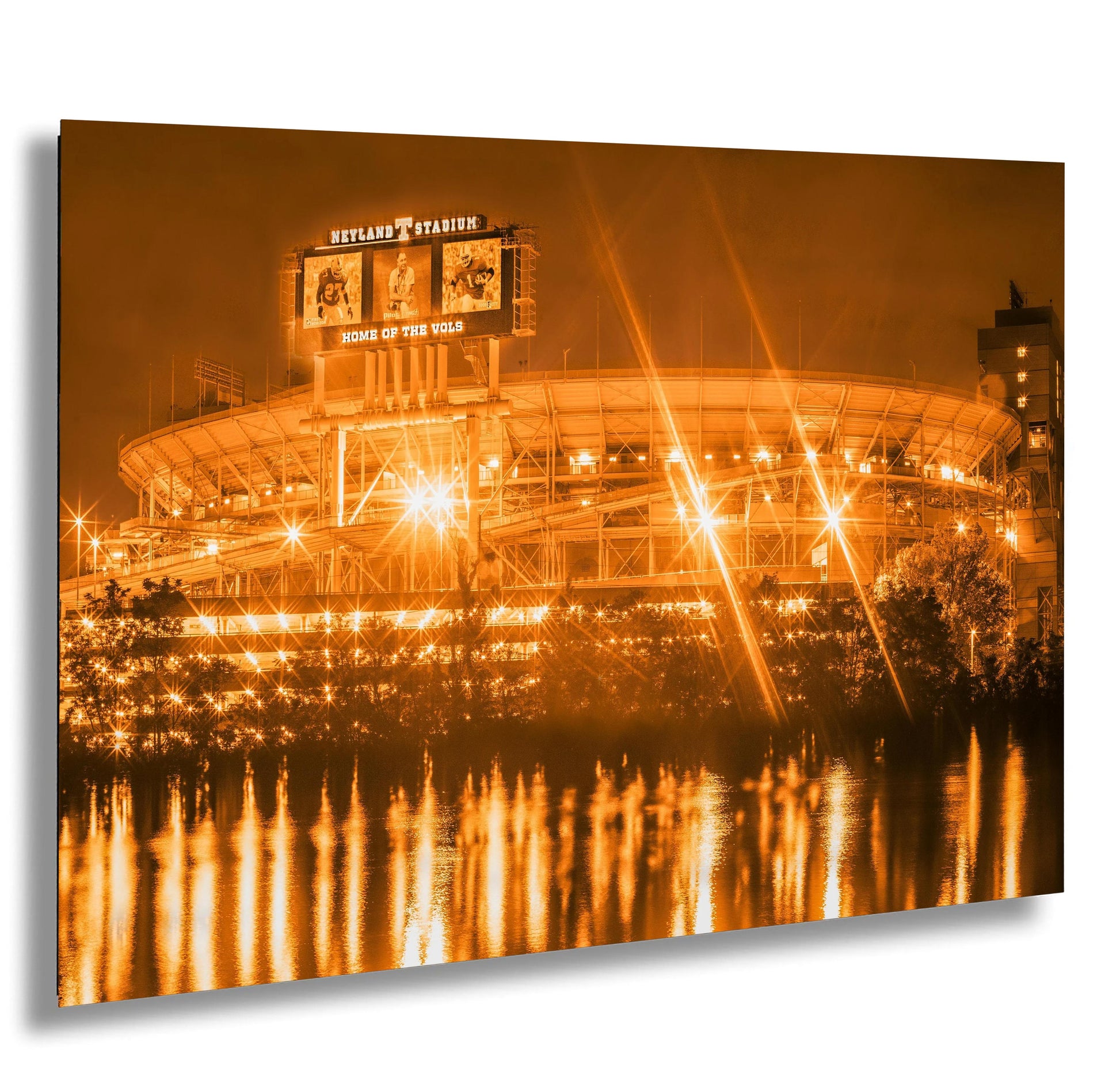 a stadium lit up at night with lights reflecting in the water