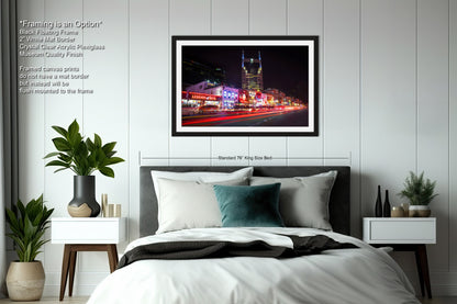 a bedroom with a large bed and a picture hanging on the wall