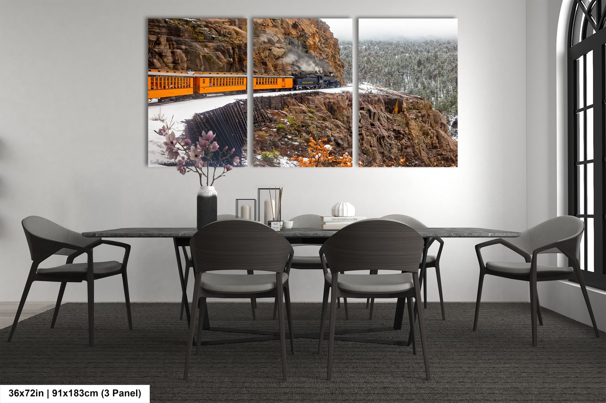 a dining room table with chairs and a painting on the wall