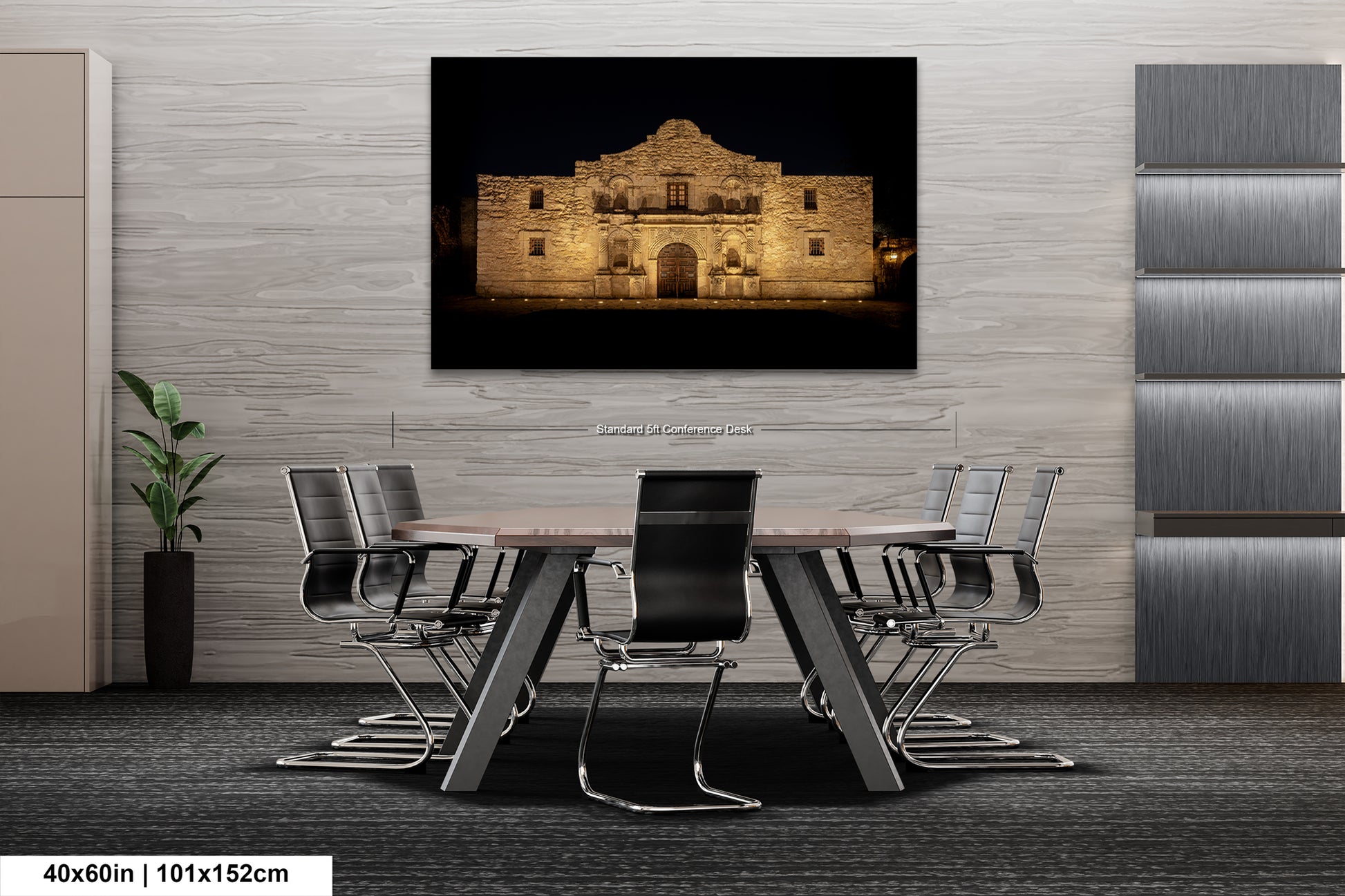 a modern office space with a large framed photograph of the Alamo in the background, mounted on the wall above a wooden table surrounded by chairs.