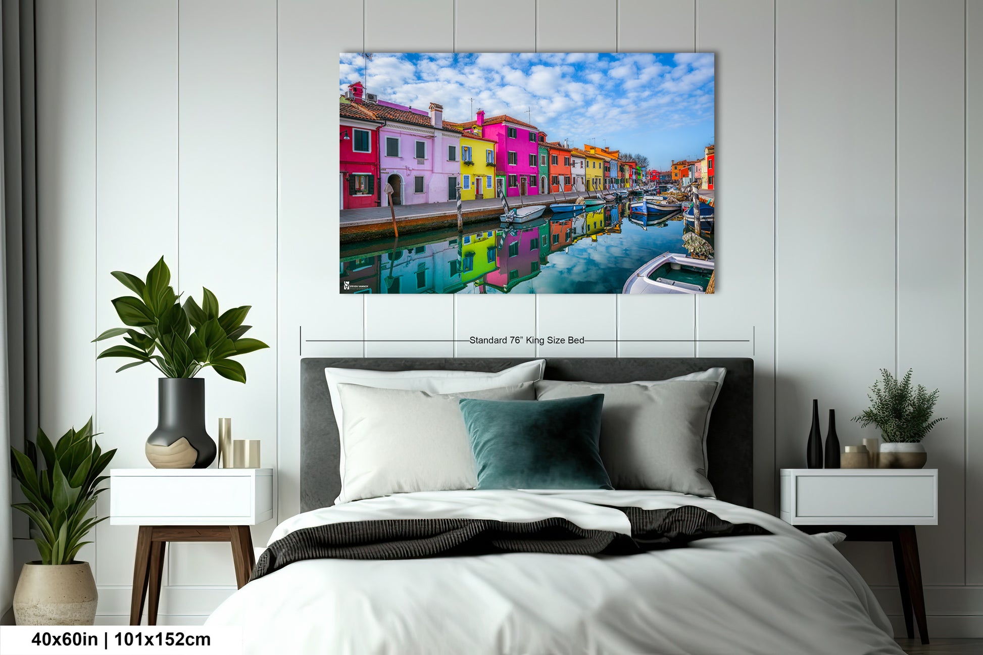 a bed room with a neatly made bed and a painting on the wall