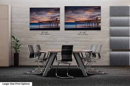 a dining room table with chairs in front of two pictures of a pier