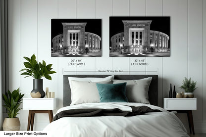 a bedroom with a bed and nightstands, along with two framed photographs of Yankee Stadium, a baseball stadium, hanging on the wall.