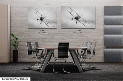 a dining room table with chairs and two pictures on the wall