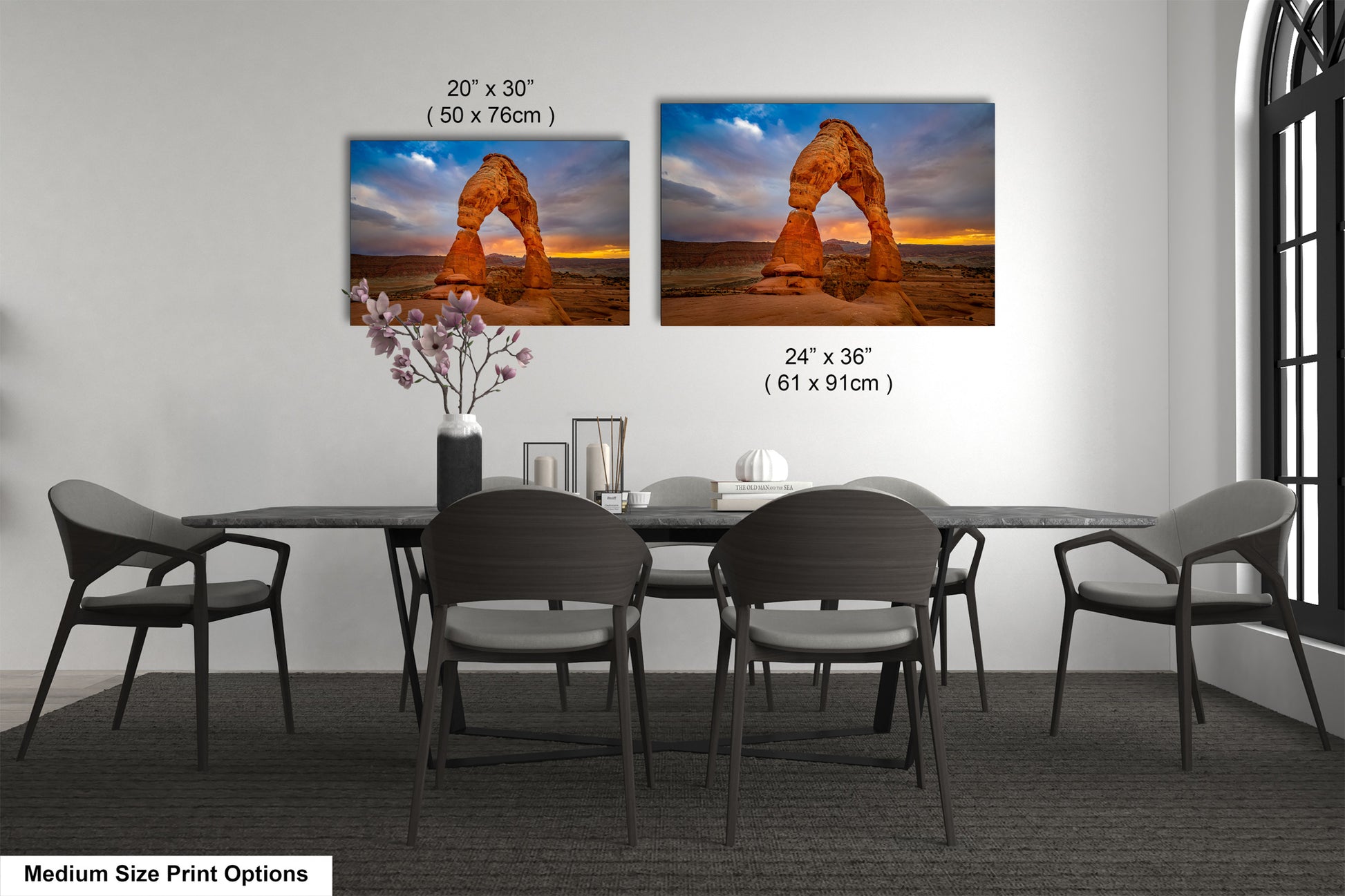 a dining room table with four chairs and two pictures on the wall