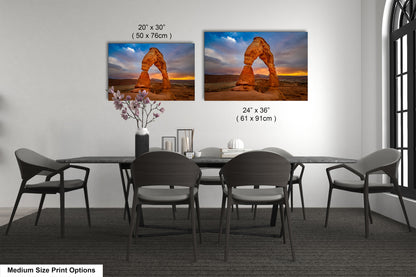 a dining room table with four chairs and two pictures on the wall