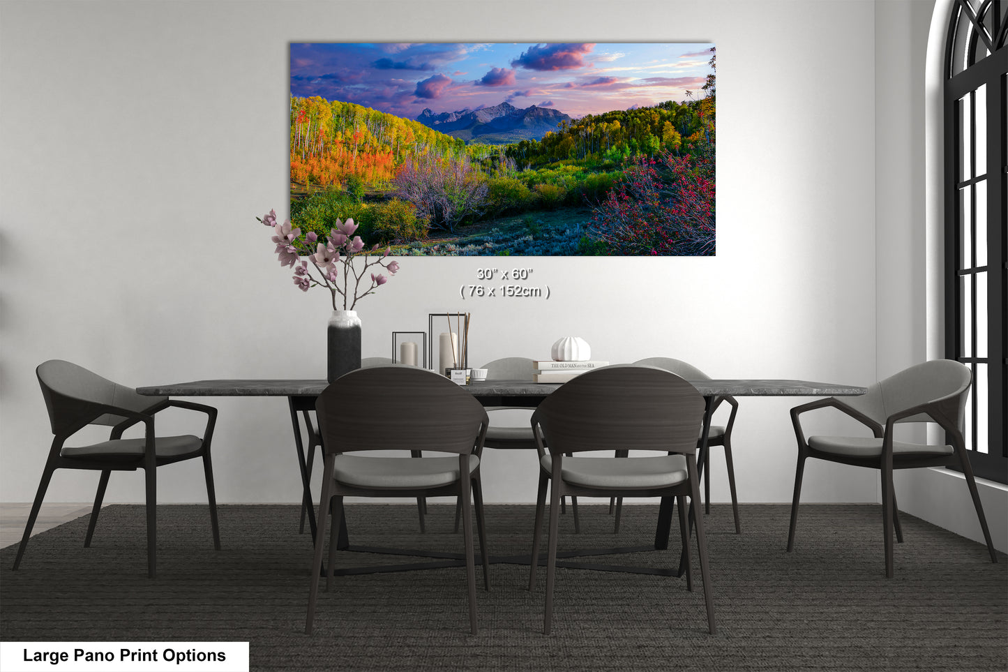 a dining room table with chairs and a painting on the wall