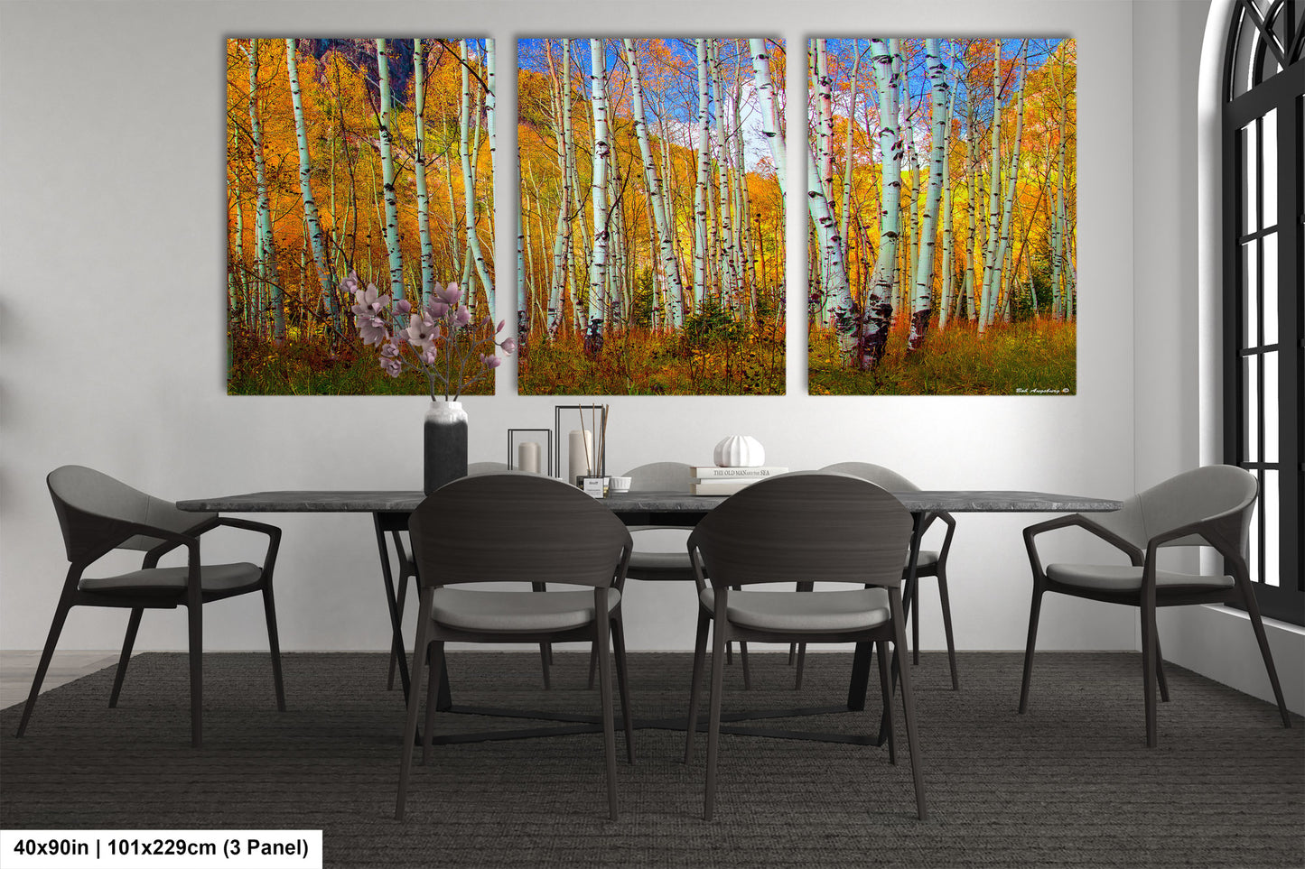 a dining room table with four chairs and a painting on the wall