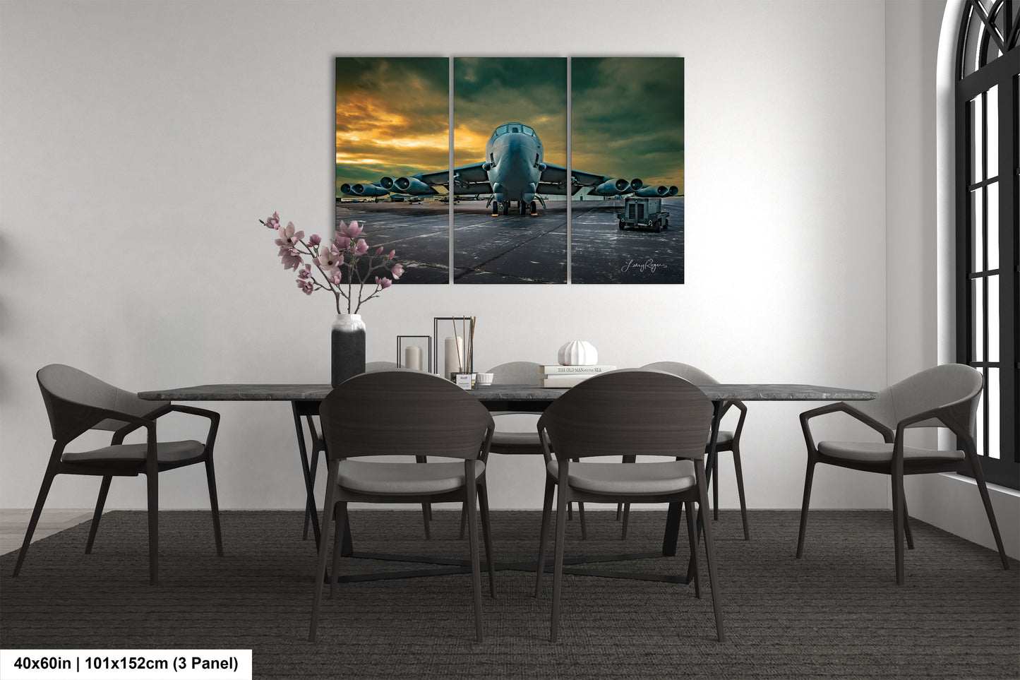 a dining room table with chairs and a painting on the wall