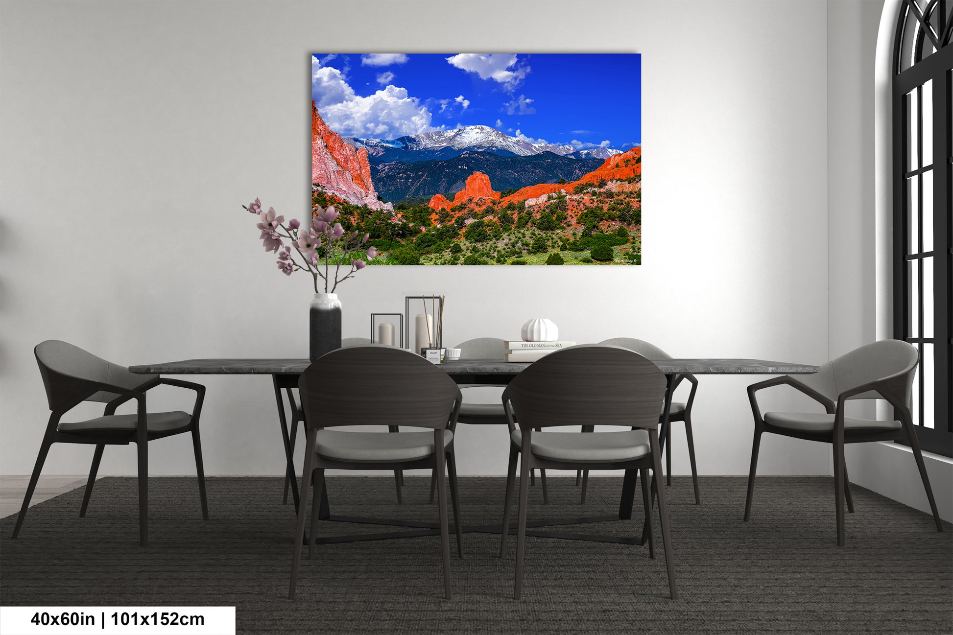 a dining room table with chairs and a painting on the wall