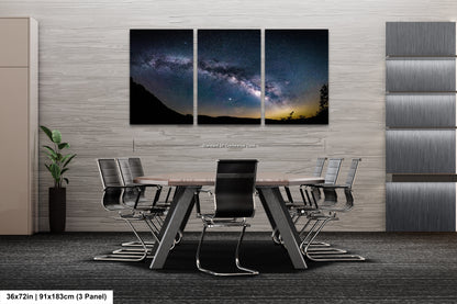 a dining room table with chairs and a wall hanging