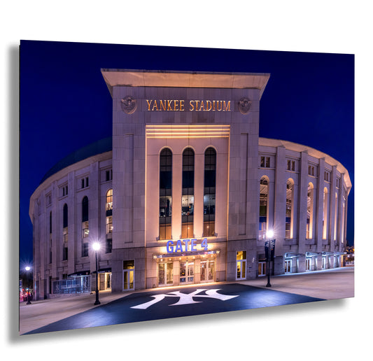 the Yankee Stadium, a large stadium located in New York City, illuminated at night.