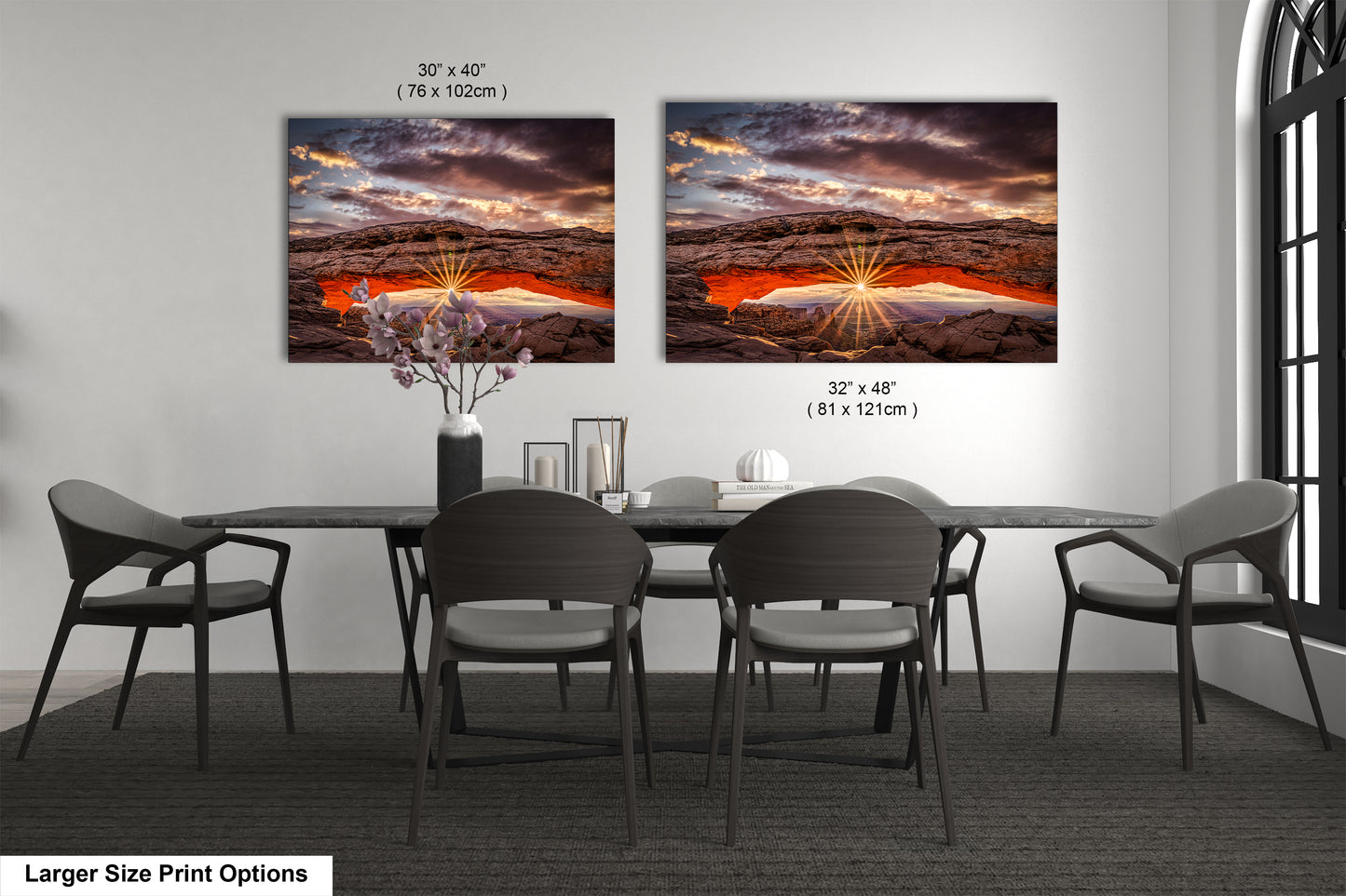 a dining room table with four chairs and two pictures on the wall