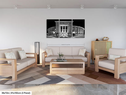 a modern living room with a large black and white photograph of a stadium or arena displayed on the wall. The room is furnished with a sofa, two chairs, and a coffee table. The overall design and layout of the room create a comfortable and inviting atmosphere.