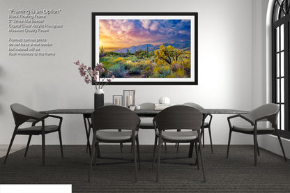 a painting of a desert scene hangs above a dining room table