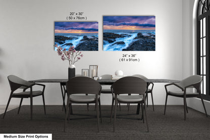 a dining room table with four chairs and a vase of flowers