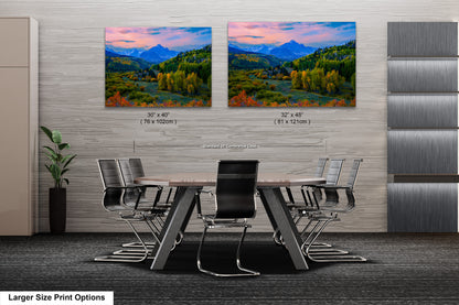 a dining room table with chairs and a painting on the wall