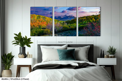 a bedroom with a bed and two paintings on the wall