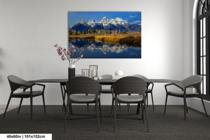 a dining room table with chairs and a painting on the wall