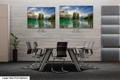 a dining room table with chairs in front of a wall with two pictures of mountains
