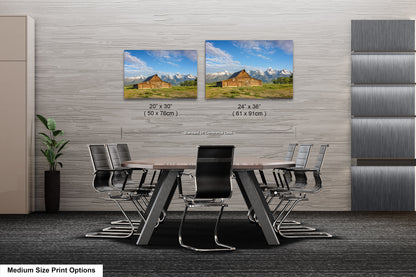 a dining room table with chairs and two pictures on the wall