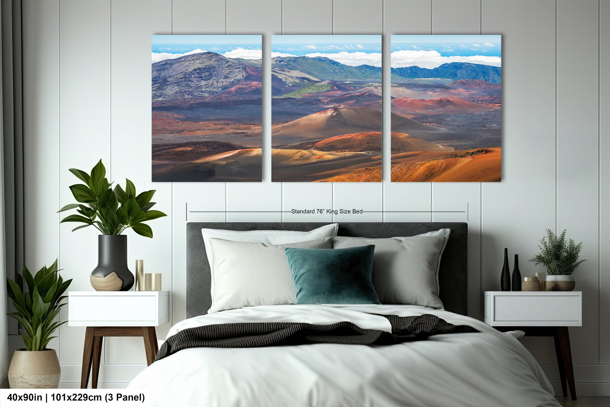 The image is a large bedroom with a bed, nightstands, and potted plants. Above the bed, there is a large painting depicting a scenic landscape with mountains, hills, and a desert. The painting is divided into three panels, each showing a different part of the landscape. The painting is framed by a white border, and the dimensions are provided as "40in (101.29cm) (3 panel)".